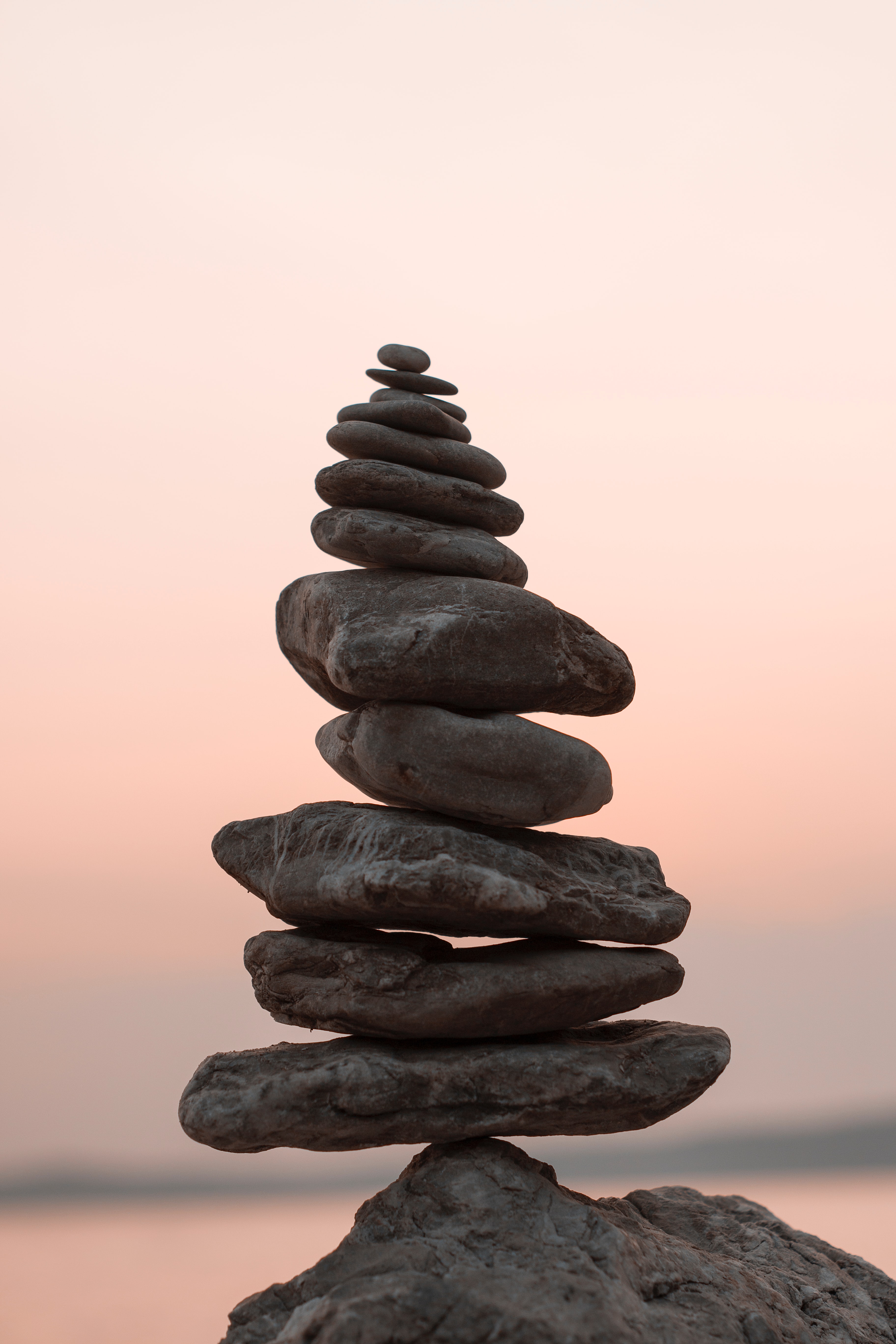 A stack of flat rocks near the beach during a sunset.